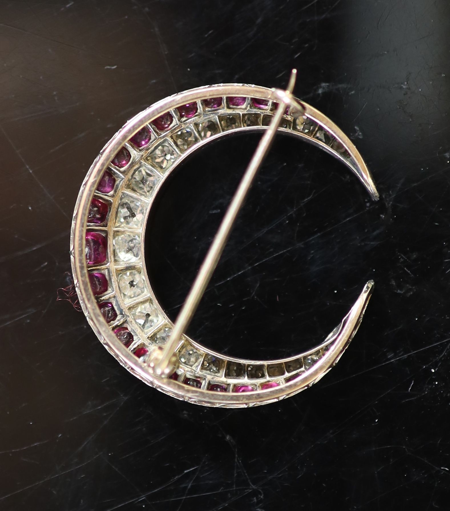 A late Victorian gold, graduated diamond and graduated cabochon ruby set two row crescent brooch